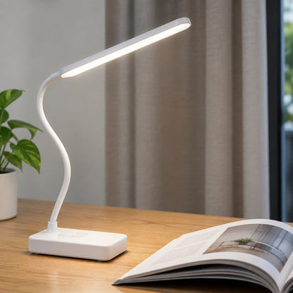 Lampe de bureau LED blanche allumée au-dessus d’un livre ouvert